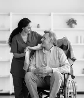 caregiver putting blanket on senior