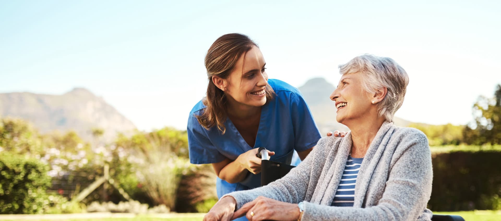 caregiver looking to senior while smiling