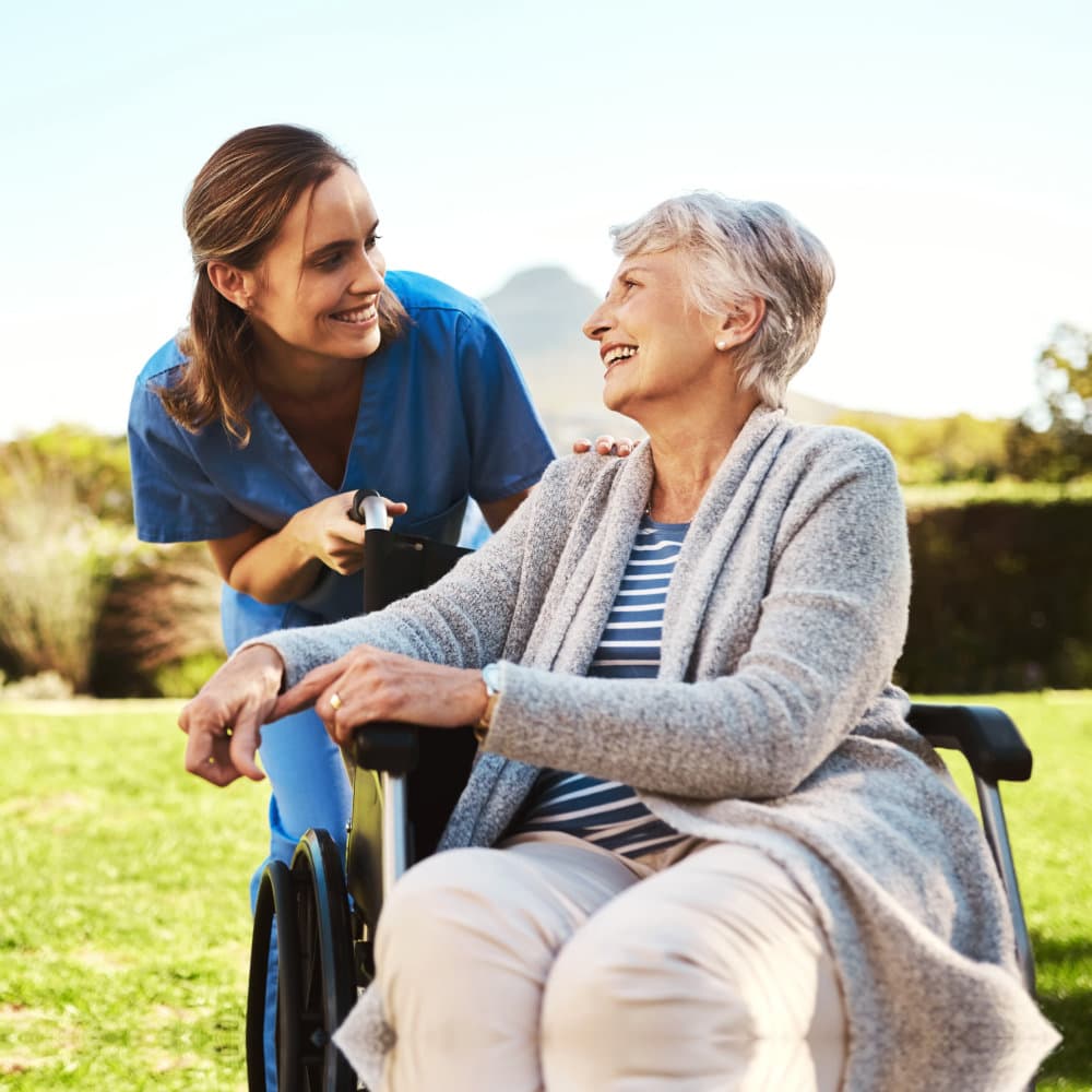 caregiver looking to senior while smiling