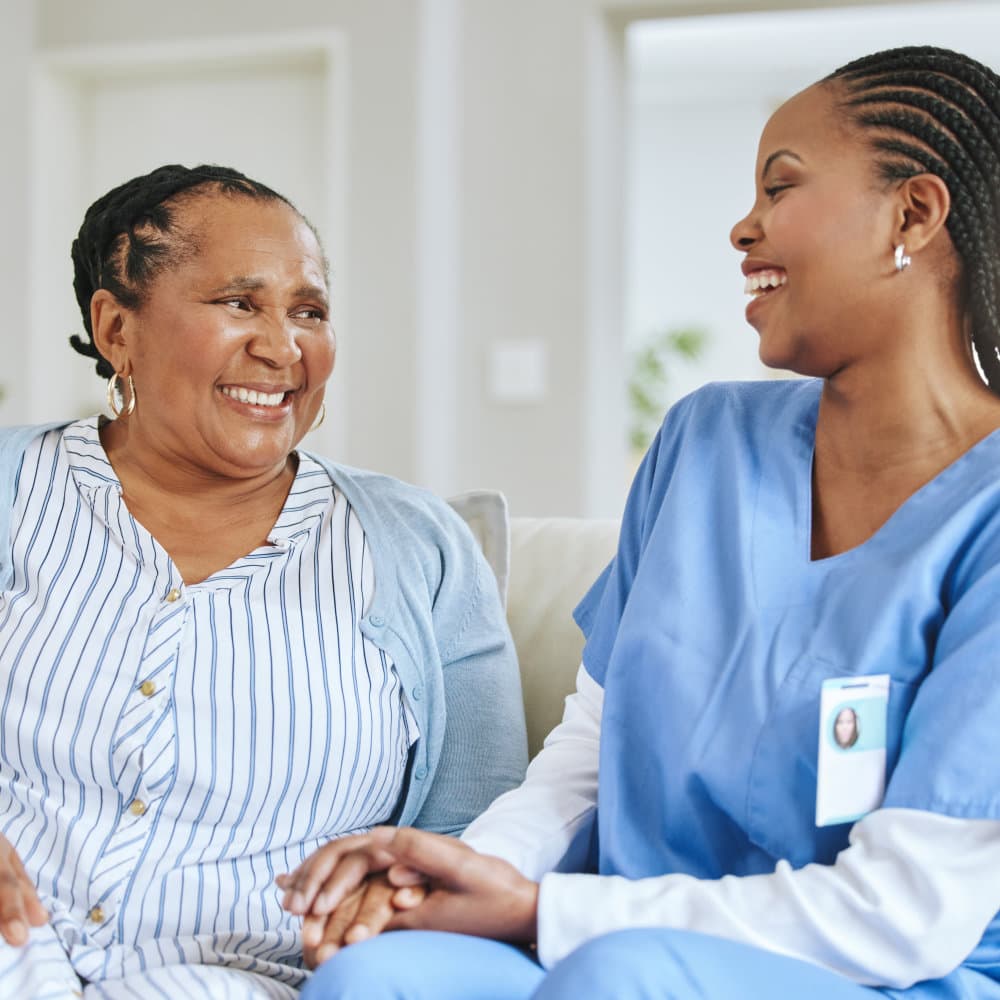 nurse and laughing together for support, healthcare and happiness at retirement home.