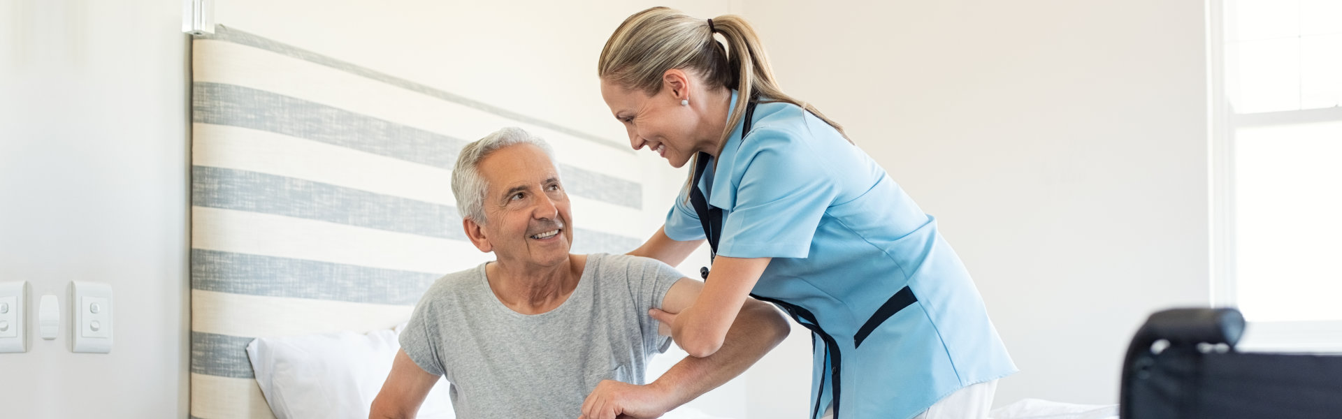 caregiver assisting senior on standing